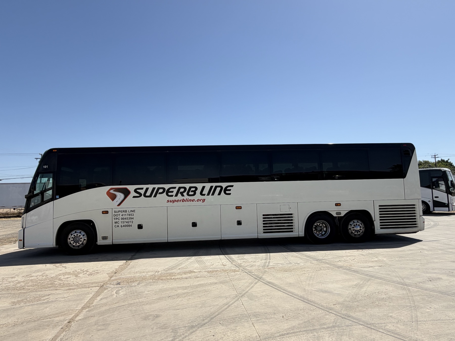White Superb Line full-size charter bus, coach 101, photographed from the side